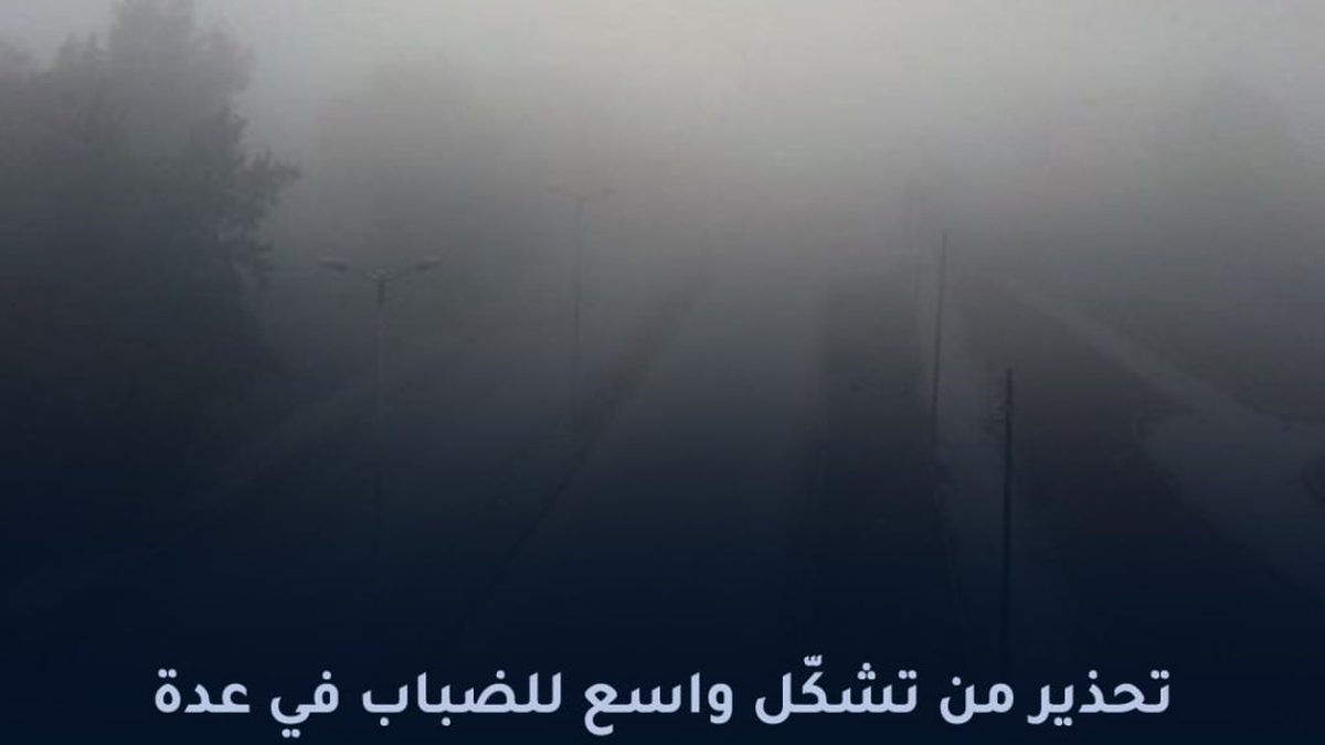 طريق سريع يغطيه الضباب الكثيف مع مصابيح سيارات تخترق الرؤية المنخفضة